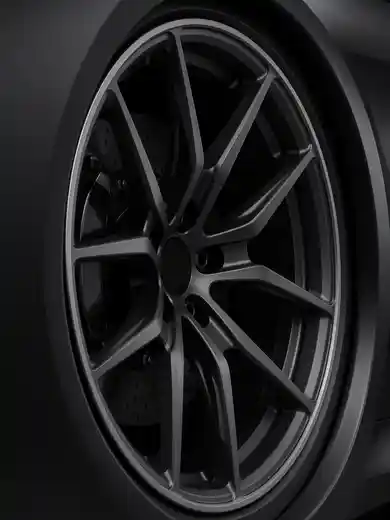 A satin black forged wheel on a dark car.